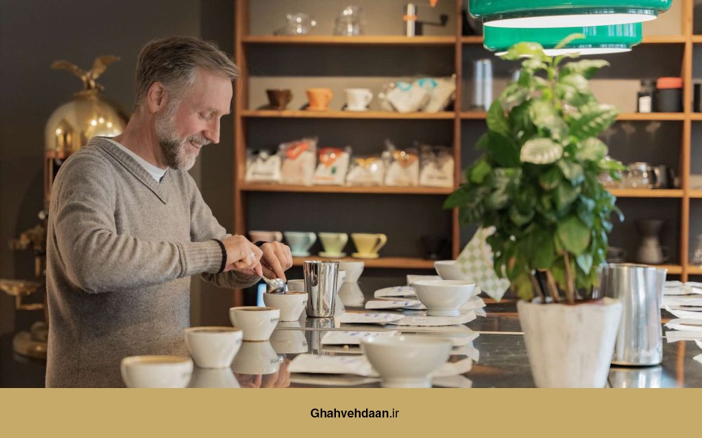 یک کارشناس قهوه در حال انجام تست طعمی (کاپینگ) در یک محیط حرفهای، با لبخند و تمرکز.