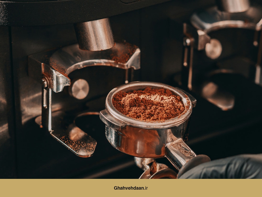 یک پورتافیلتر پر از قهوه آسیابشده که از دستگاه آسیاب صنعتی Mahlkönig خارج شده است و برای عصارهگیری اسپرسو آماده میشود.