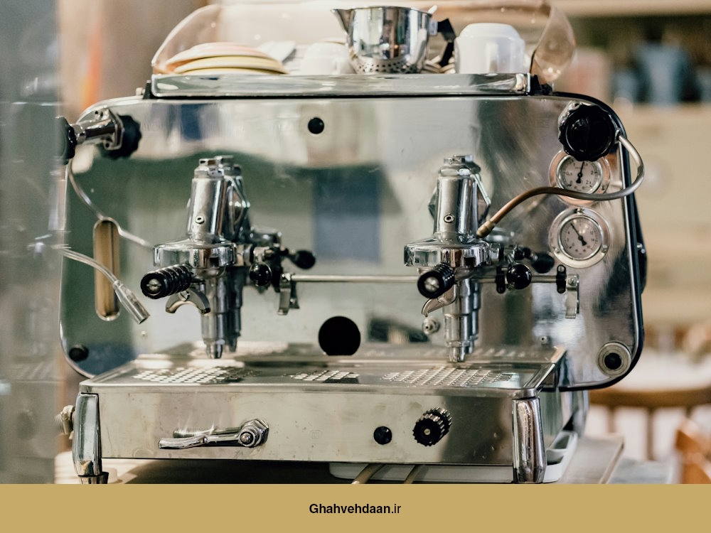 یک دستگاه اسپرسو کلاسیک مدل فاِما با طراحی استیل براق، دارای دو گروپهد و فشارسنجهای مکانیکی، در یک محیط کافه قدیمی.