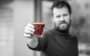 تصویر یک فنجان فلت رد در دستان یک مرد