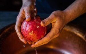 یک انار در حال شست و شو برای آماده سازی فلت رد